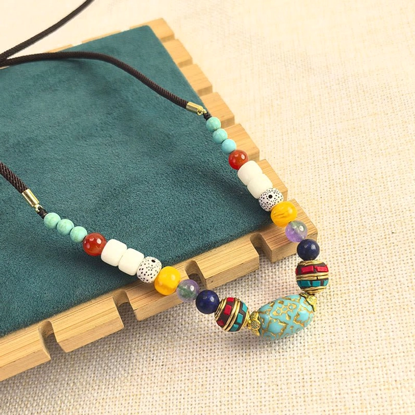 Authentic Tibetan turquoise chakra necklace featuring large carved turquoise bead centerpiece with multi-color stone accents