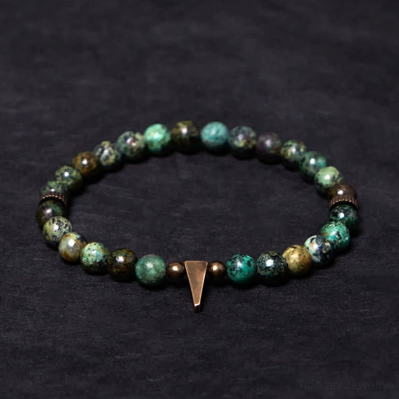Tibetan bracelet with short copper spike charm and bronze metal spacer beads close-up