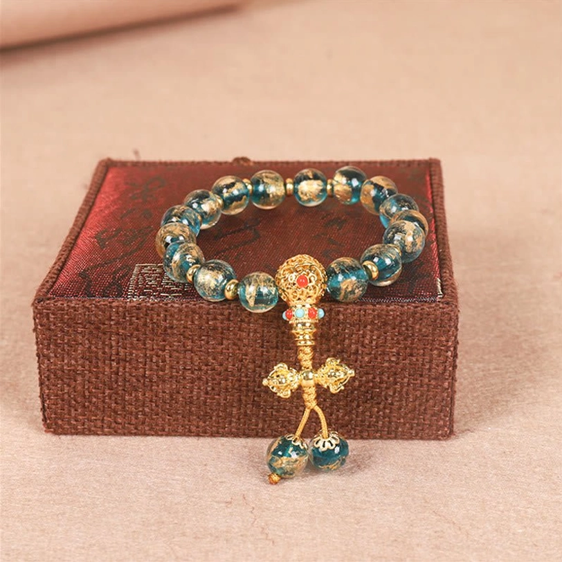Turquoise Dorje Tibetan bracelet featuring turquoise beads and intricate gold vajra symbol pendant