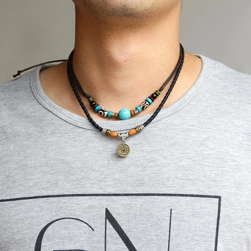 Turquoise Dzi bead protection necklace worn around adult male neck with casual grey t-shirt background showing comfortable fit