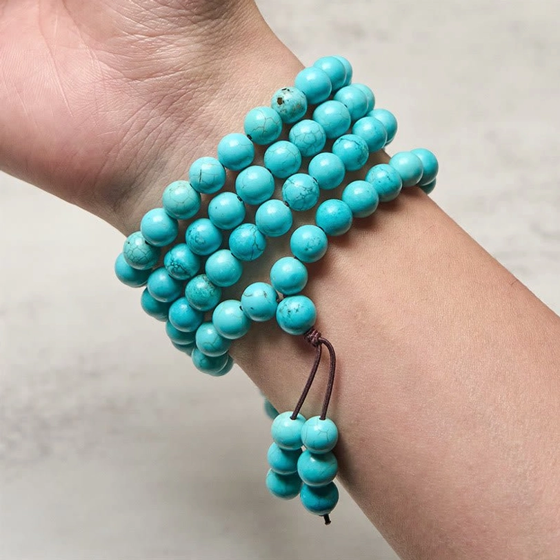 Turquoise 108 bead mala worn on wrist wrapped multiple times as bracelet - natural stone beads styled on human forearm