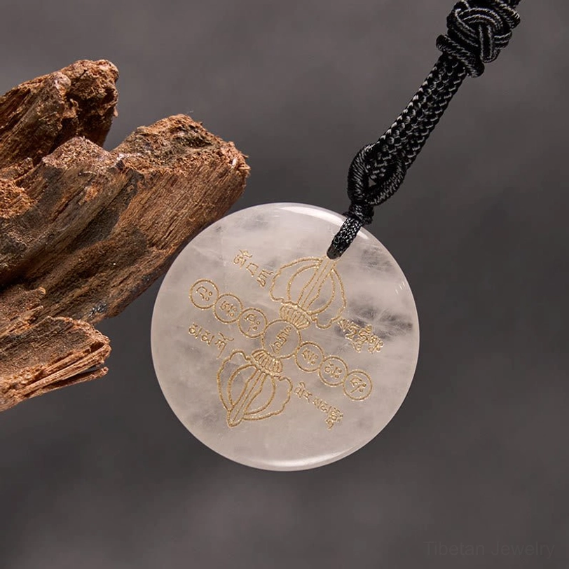 Detailed view of Vajra Dorje Tibetan necklace pendant showing golden Sanskrit and Dorje symbols on natural stone surface