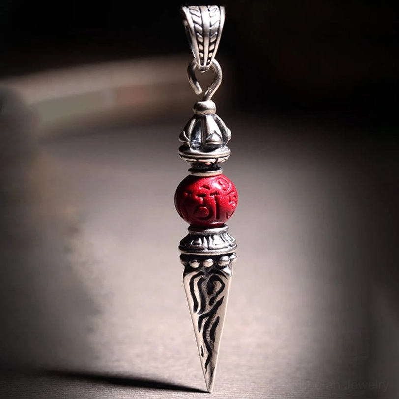 Vajra pendant close-up with clear carved silver patterns and prominent red mantra cinnabar bead detail