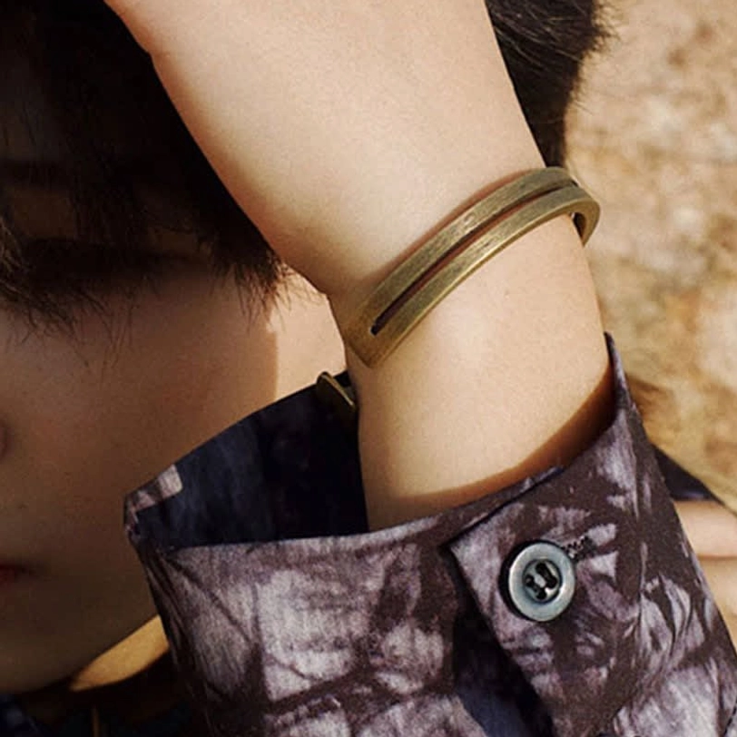 Adjustable open cuff bracelet close-up on wrist showing brushed antique bronze finish and comfortable fit