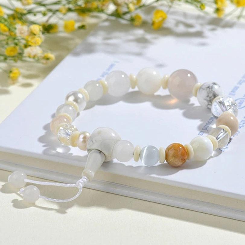 18-bead white agate pearl luck bracelet - overhead flat lay on book with yellow flowers showing mixed natural gem beads