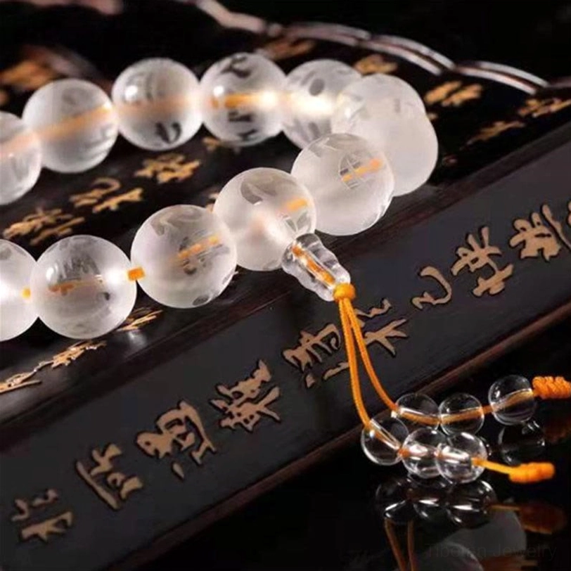 White crystal Om Mani Padme Hum bracelet close-up showing transparent polished beads and sacred geometry