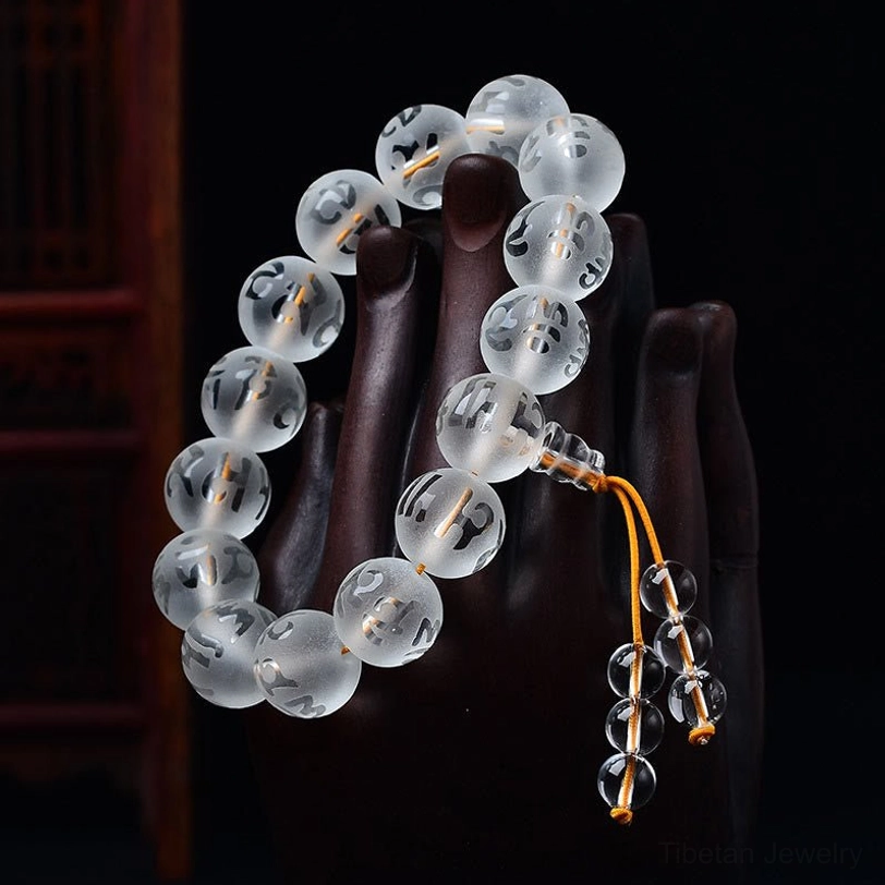 White crystal prayer bracelet with transparent engraved beads shown on hand form wearing meditation jewelry