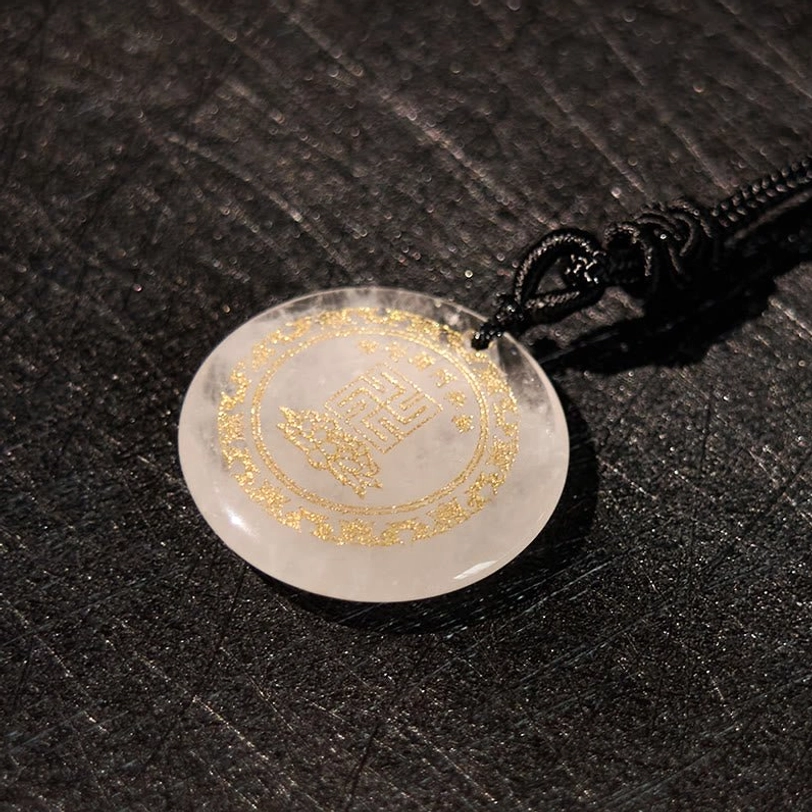 Clear quartz pendant close-up showing translucent stone with golden border on leather