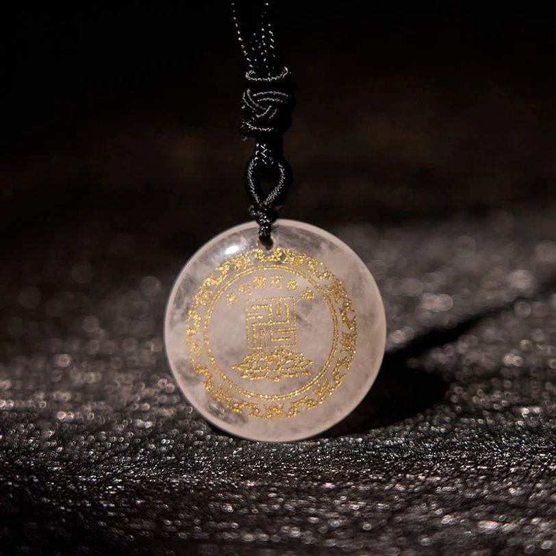 Clear white crystal Buddhist pendant necklace with golden engravings on dark leather