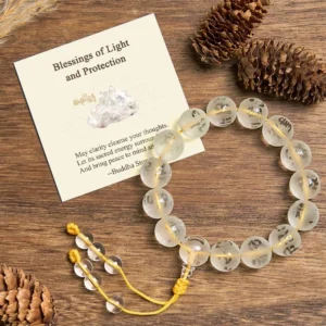 White crystal Om Mani Padme Hum meditation bracelet with yellow tassel on wooden surface with natural elements