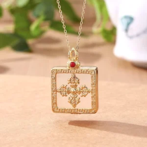 White jade double dorje gold-plated square pendant necklace front view with geometric frame and red gem accent