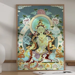 White Tara handmade embroidered Thangka tapestry displayed on home desk with teal floral background and gilt trim accents