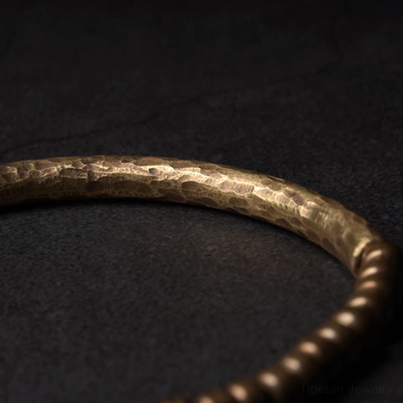 Wide hammered brass bracelet featuring irregular texture and vintage bronze finish, showcasing artisanal craftsmanship