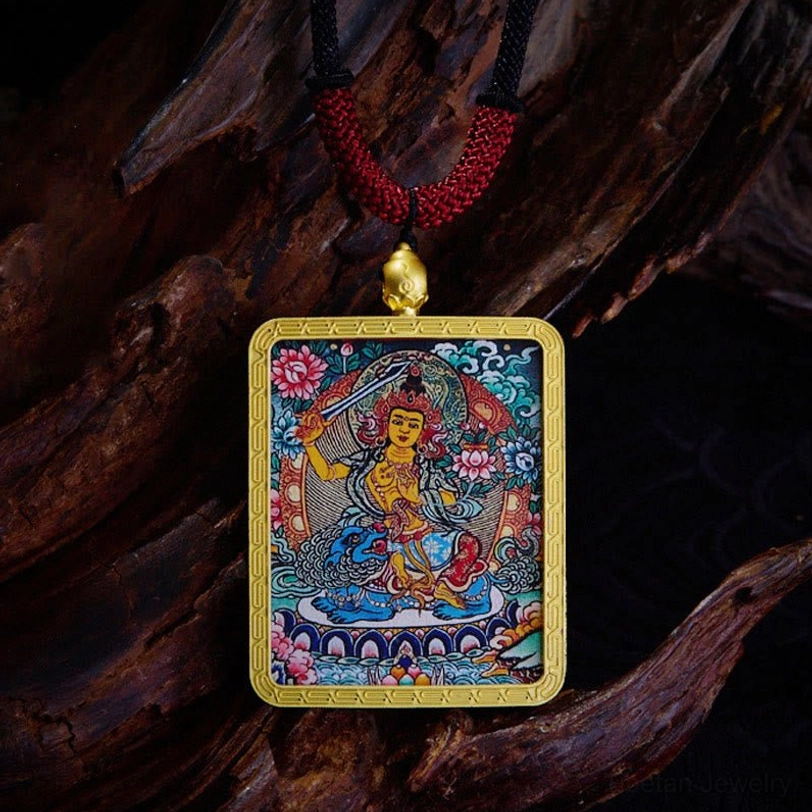 Tibetan Yellow God of Wealth thangka pendant with gold border and vibrant colorful deity artwork on dark wood background