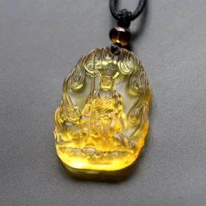 Yellow Ksitigarbha Buddha Liuli crystal pendant with flame carved border, seated Bodhisattva holding staff and lion symbol, black braided cord with amber bead accent