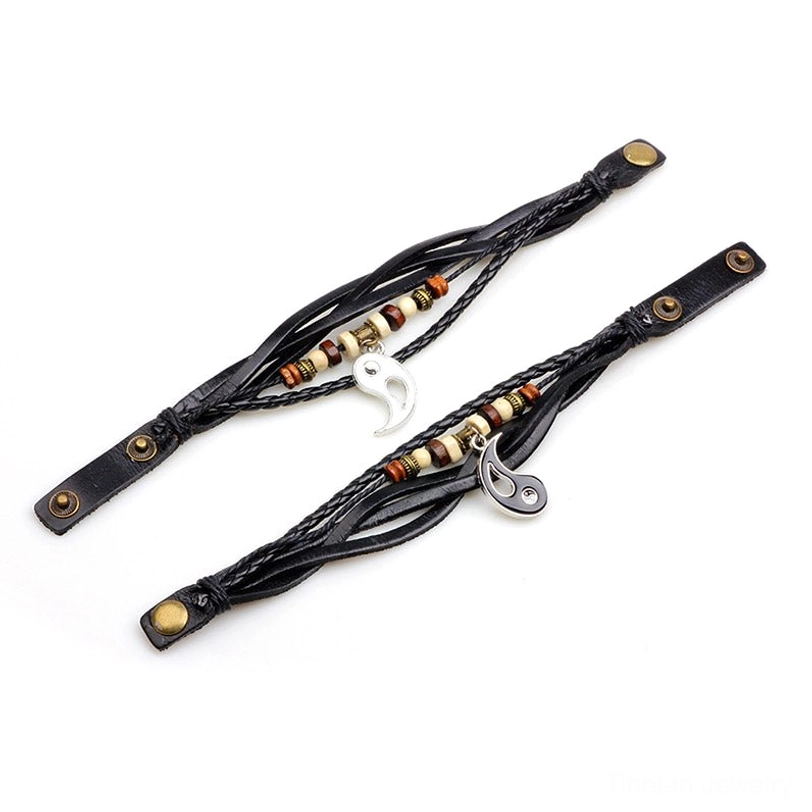 Adjustable yin yang leather bracelet with metal snap fasteners and partial charm detail