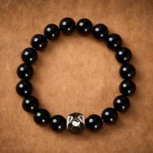 Tibetan Yin Yang harmony bracelet featuring smooth black obsidian beads and faceted accent bead