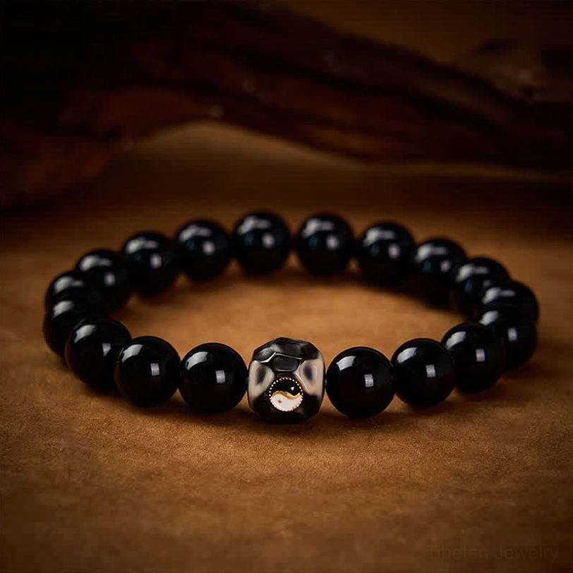 Side angle view of Yin Yang beaded bracelet showing elastic string and glossy black round beads