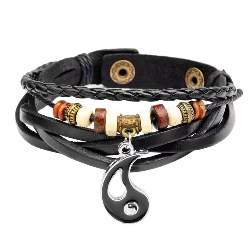 Yin yang balance bracelet flat lay showing layered cowhide leather and brown-white wooden beads