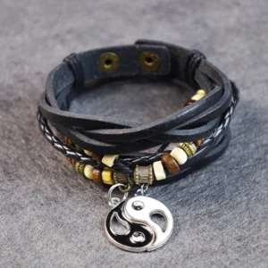 Yin yang leather bracelet overhead view showing metal snap fasteners and braided design