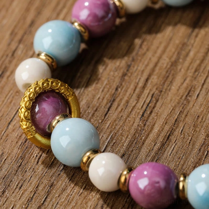 Detail shot of Zakiram bracelet beads showing gold-toned metal spacer rings and smooth incense ash porcelain beads