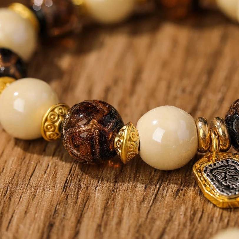Side view macro detail of Tibetan Zakiram prosperity bracelet with ceramic glazed beads and metal charm