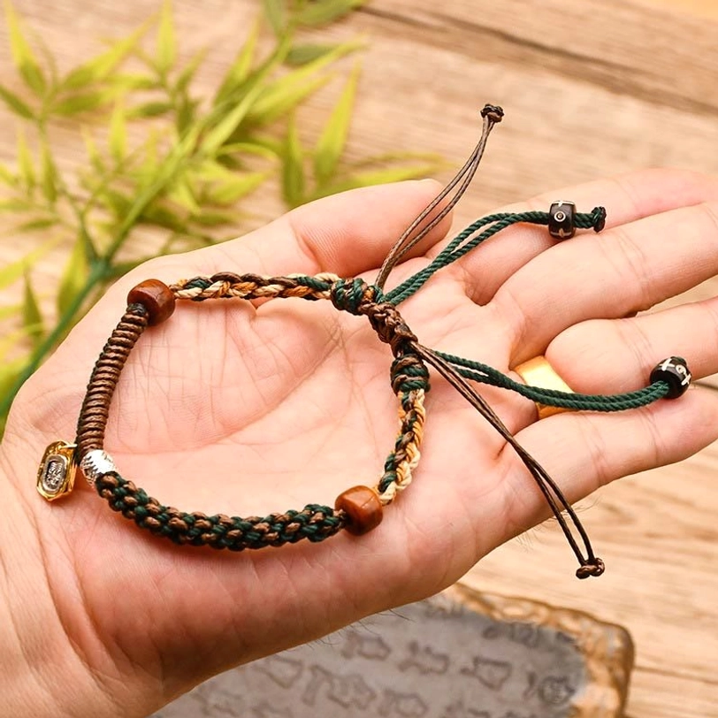 Tibetan Zakiram bracelet in green-brown held in hand with natural leaf decoration showing adjustable design