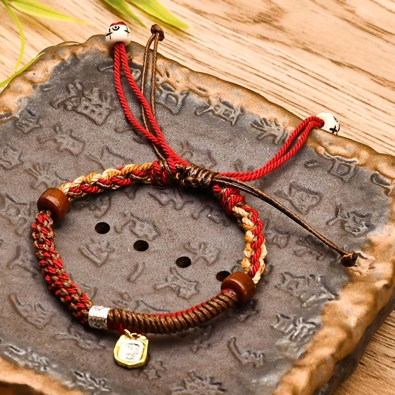 Dark red Zakiram goddess of wealth bracelet with woven cords, wooden beads, metal charm and adjustable pull straps