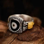 925 Sterling Silver Zakiram Dzi Bead Ring with single-eye protection symbol, three-quarter front view showing intricate scroll engravings and gold-tone accents