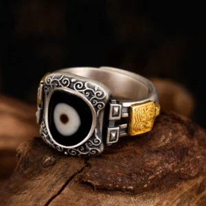 925 Sterling Silver Zakiram Dzi Bead Ring with single-eye protection symbol, three-quarter front view showing intricate scroll engravings and gold-tone accents