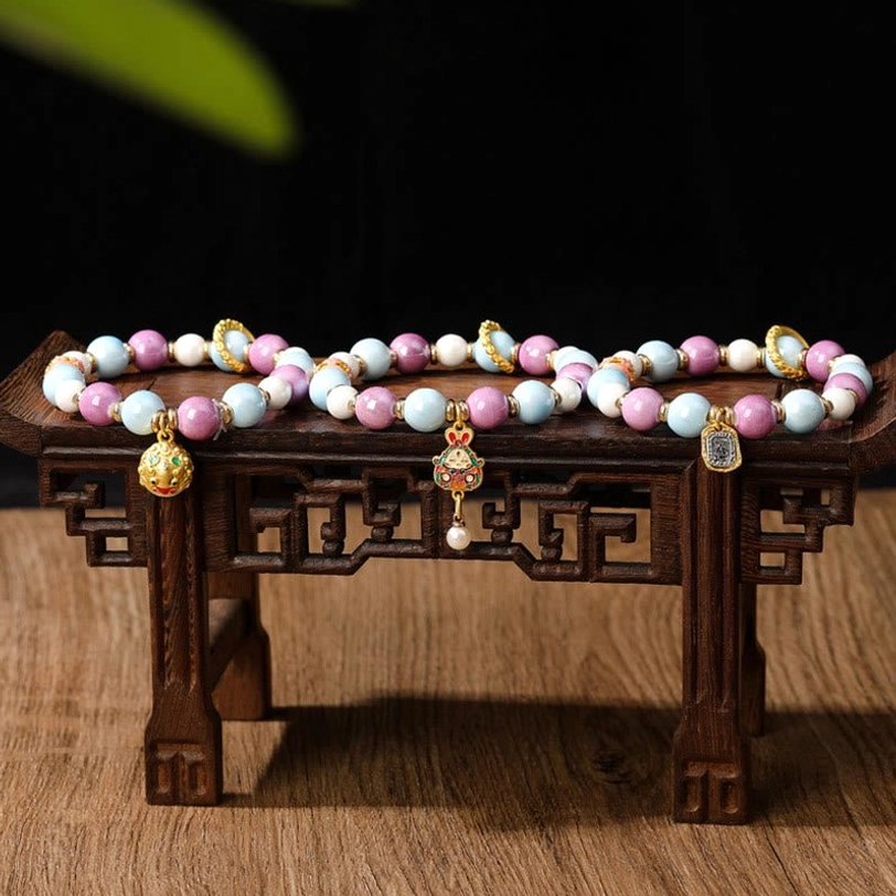 Artisan handmade Zakiram Goddess of Wealth bracelet with liuli glass and incense ash porcelain beads, lifestyle wear photo