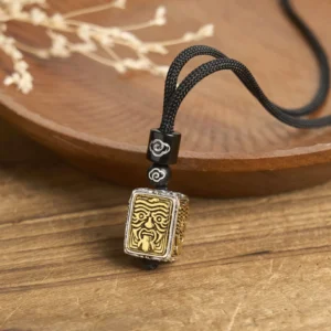 Zakiram Goddess of Wealth protection tibetan square pendant necklace with black braided rope and cloud-patterned beads, gold-silver bicolor deity relief, overhead flat lay view