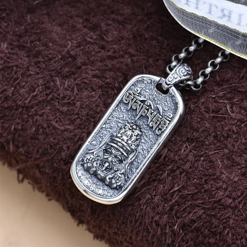 Zakiram prayer pendant necklace top-down view showing full pendant and chain on brown textile background