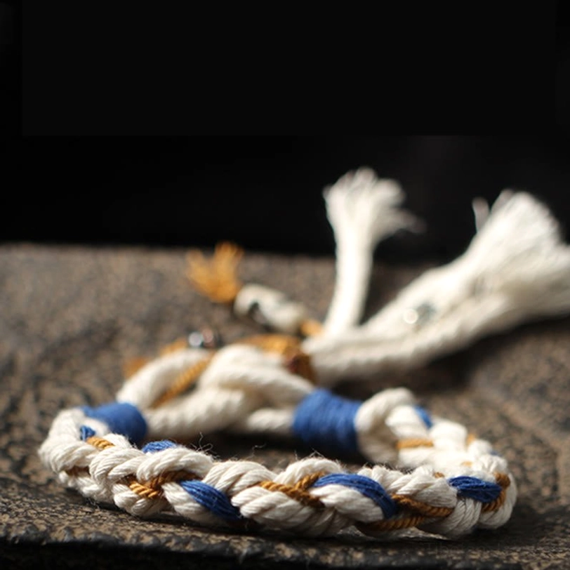 Zakiram prosperity bracelet with tri-color braided design, multiple tassels, and pendant decorations on carved wood