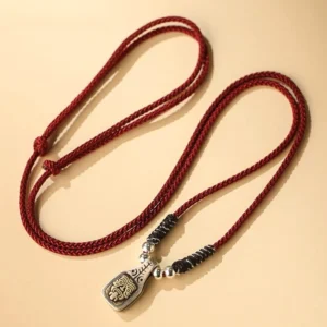 Red braided cord Zakiram Tibetan amulet necklace with silver beads and engraved goddess pendant close-up detail