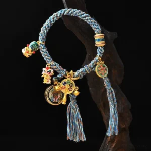 Zakiram goddess of wealth thangka bracelet with blue-brown woven string and tibetan metal charms on dark wooden surface