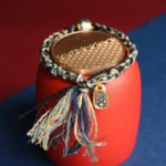 Zakiram goddess wealth Tibetan handmade bracelet blue beige black woven cord with engraved silver om mani padme hum bead and gold pendant