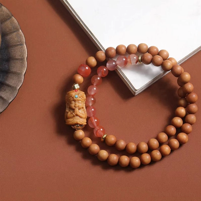 Tibetan Zakiram goddess wealth bracelet with sandalwood beads and South Red Agate stones, carved deity pendant with turquoise inlay, top view