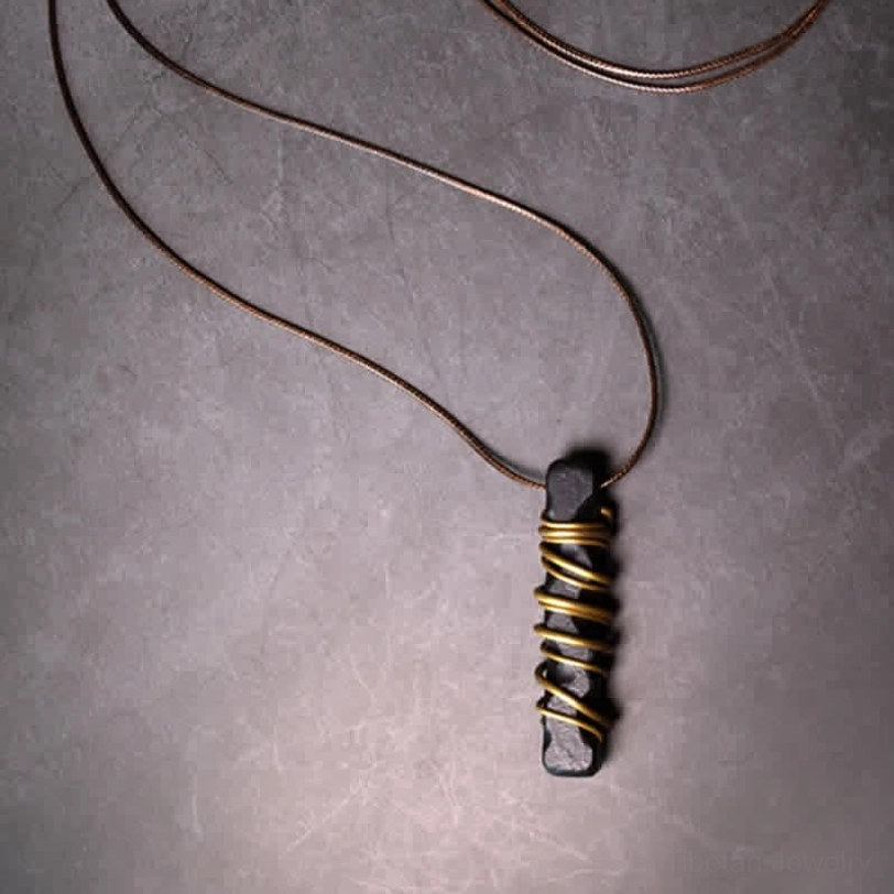 Full length Tibetan zen circle necklace overhead view, displaying 80cm brown cord and layered brass wire wrapped pendant
