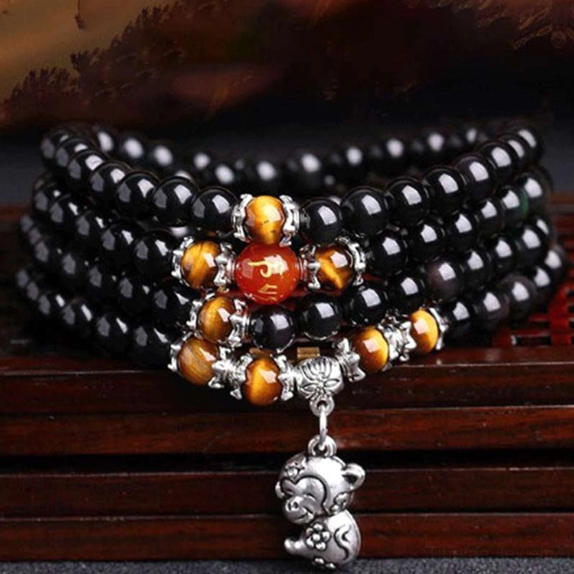 Full 108 bead zodiac mala bracelet with black obsidian, tiger eye, red agate, and monkey silver charm pendant front view