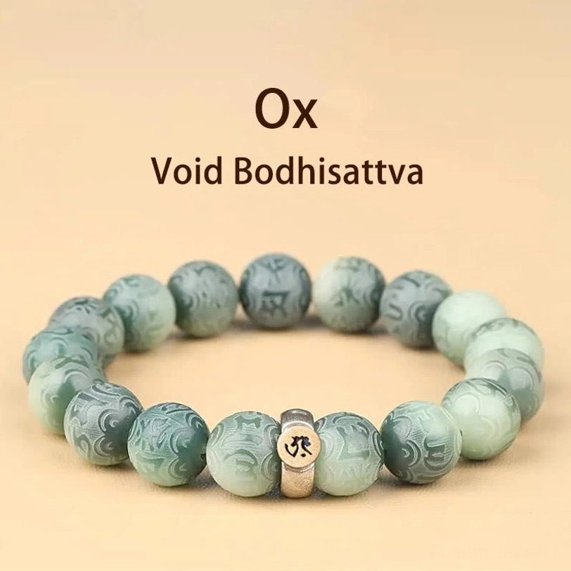 Zodiac Ox natal Buddha Bodhi seed bracelet with engraved beads and gold metal charm flat lay